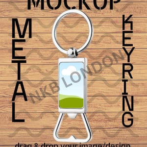 May include: Metal keyring with a rectangular insert featuring a landscape design of a blue sky and green hills. The keyring has a bottle opener at the bottom and the words "MOCKUP METAL KEYRING" are printed on a wooden background. The text "drag & drop your image/design" is also present.