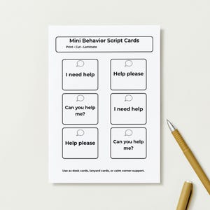 Pu&ograve; includere: Un foglio bianco di Mini Schede di Script Comportamentali con sei caselle, ognuna contenente una frase come "Ho bisogno di aiuto" e "Puoi aiutarmi?" Una penna e un cappuccio dorati sono a destra. Le schede sono per scrivania, cordino o angolo calmo.