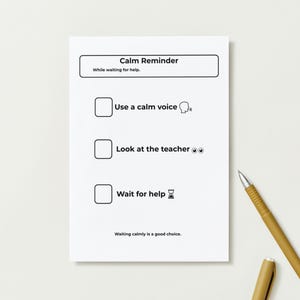 Pu&ograve; includere: Un foglio di carta bianco con il testo "Calm Reminder" e una lista di controllo con tre passaggi: "Usa una voce calma", "Guarda l'insegnante" e "Aspetta aiuto". Una penna dorata &egrave; sul lato destro del foglio.