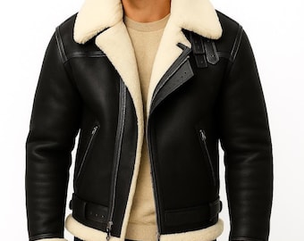 May include: Black shearling jacket with a cream-colored shearling collar and lining. The jacket features a zipper closure, a buckled belt at the waist, and a shearling trim on the cuffs. The jacket has a classic aviator style.