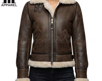May include: A brown leather jacket with a cream-colored shearling collar and lining. The jacket features a zip-up front, two pockets, and buckle details. The logo "fit APPAREL" is visible in the upper left corner.