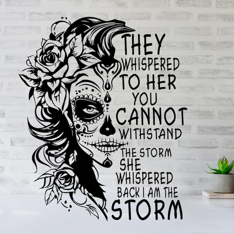 May include: Black and white graphic design featuring a woman with a sugar skull face and floral headpiece. The text reads "They whispered to her you cannot withstand the storm she whispered back I am the storm."