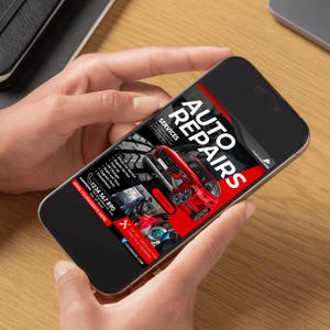 May include: A mobile phone displaying a black and red advertisement for auto repairs. The ad features a red car and the text "AUTO REPAIRS" in large white letters. The ad also includes a list of services offered, a phone number, and a website address.
