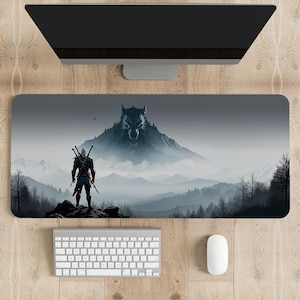 Könnte beinhalten: Eine graue und weiße Gaming-Mausmatte mit einem Wolf und einer Figur, die auf einem Berg in einem nebligen Wald steht.