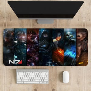 Puede incluir: Una alfombrilla de ratón para juegos colorida con personajes de la serie de videojuegos Mass Effect. La alfombrilla tiene un fondo negro con un logotipo N7 rojo y blanco en la esquina inferior izquierda.