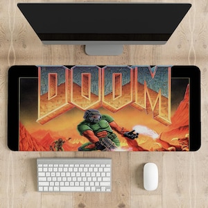 May include: A black and red gaming mouse pad with a graphic of a green demon holding a gun and the word "DOOM" in large letters.