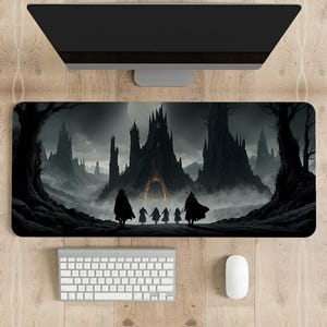 Könnte beinhalten: Rechteckiges Mauspad mit einer dunklen Fantasy-Landschaft mit einer Burg, Figuren und Bäumen. Die Farbpalette ist hauptsächlich Schwarz und Grau, mit einem Hauch von Gold. Eine Tastatur, eine Maus und ein Monitor sind ebenfalls sichtbar.