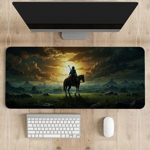 Peut inclure: Un tapis de souris de jeu noir et vert avec une silhouette d'une personne à cheval devant un paysage de coucher de soleil.