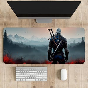 May include: A gaming mouse pad featuring a fantasy character with swords on their back, standing in front of a misty mountain landscape with a red and orange sunset.