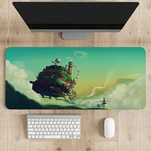 May include: A green and blue desk mat with a cartoon image of a flying house with a green roof and a chimney. The house is flying over a white cloud with a small figure in a dress standing on the cloud.