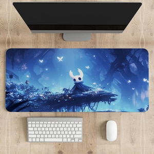 May include: A blue and purple gaming mouse mat featuring a stylised illustration of a character from the video game Hollow Knight. The character is standing on a platform with a blue background and surrounded by white butterflies.