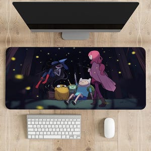 May include: A black and white cartoon mouse mat featuring Finn, Jake, Marceline, and Bubblegum from the animated series Adventure Time. The characters are standing in a forest at night with fireflies in the background.