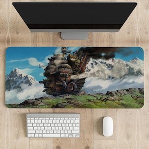 May include: A large, detailed, illustrated mousepad featuring a flying steampunk-style airship with a dragon-like tail, soaring over a mountain range with clouds and a blue sky.