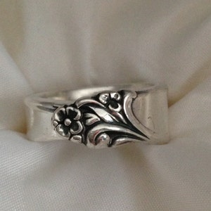 May include: A silver ring made from a repurposed spoon with a floral design.