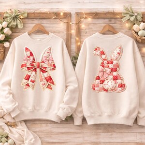 Könnte beinhalten: Zwei cremefarbene Sweatshirts, jedes mit einem einzigartigen Oster-Design. Eines zeigt eine große Schleife mit rotem und rosa Patchwork, das andere einen Patchwork-Hasen mit einer rosa Schleife. Beide Designs haben ein gestepptes Aussehen, ideal für den Frühling.