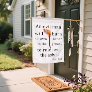 May include: White outdoor flag with the quote "An evil man will burn his own nation to the ground to rule over the ashes" and a torch illustration. The flag is hanging on a wooden rod.
