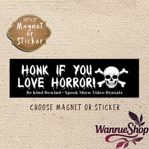 May include: Black rectangular magnet or sticker with the text "HONK IF YOU LOVE HORROR!" in white, and a skull and crossbones graphic. The dimensions are approximately 25cm x 7.6cm. The text "Be Kind Rewind • Spook Show Video Rentals" is also included.