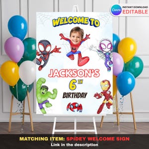 May include: A birthday welcome sign featuring the text "WELCOME TO JACKSON'S 6TH BIRTHDAY" with superhero illustrations. The sign includes a photo of a child and is surrounded by colorful balloons. The sign is on an easel.