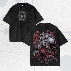 May include: Two black t-shirts with a distressed wash. One shirt features a white circular design on the front. The other shirt displays a detailed graphic on the back, depicting a warrior figure in armor amidst a red and gray scene.