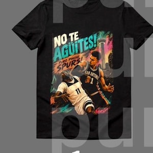 Puede incluir: Camiseta negra con un gráfico de baloncesto que muestra a dos jugadores en acción. El diseño incluye el texto "NO TE AGUITES! PURO PINCHE SPURS!" y un paisaje urbano con una torre. Los jugadores llevan camisetas en blanco y negro.