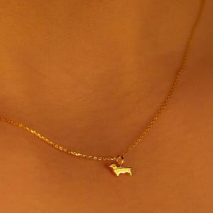 May include: A gold chain necklace with a small gold dog pendant.