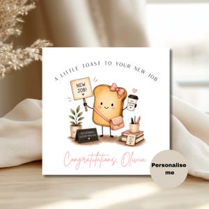 May include: A square greeting card featuring a cartoon slice of toast with a pink bow and bag, holding a sign that says NEW JOB! and a coffee cup. Text reads A LITTLE TOAST TO YOUR NEW JOB and Congratulations, Olivia. Includes a plant and books.