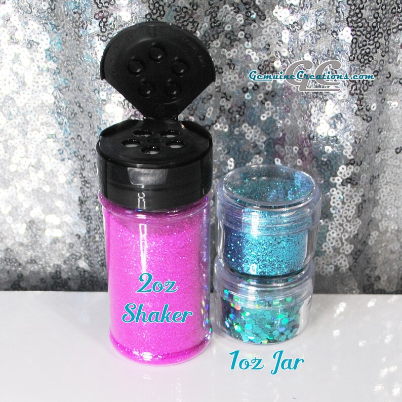 Peut inclure: Deux contenants de paillettes, l'un est un flacon shaker de 2 oz avec des paillettes roses, l'autre est un pot de 1 oz avec des paillettes bleues. Les deux contenants ont un corps en plastique transparent et un couvercle noir.