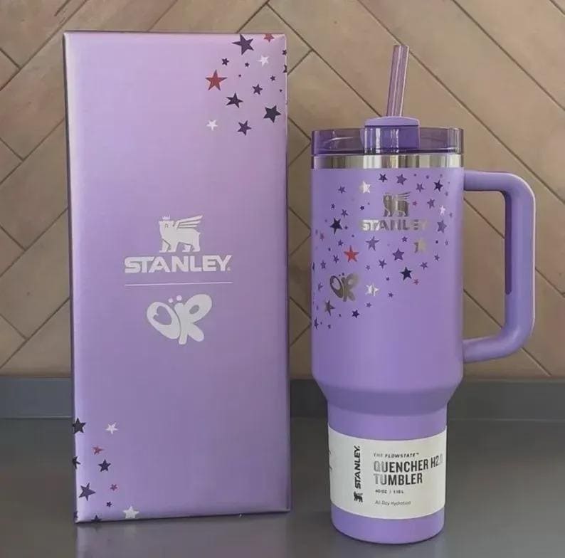 Peut inclure: Un gobelet Stanley Quencher H2.0 lavande avec une poign&eacute;e, une paille et un couvercle, &agrave; c&ocirc;t&eacute; d'une bo&icirc;te assortie. Le gobelet et la bo&icirc;te sont d&eacute;cor&eacute;s d'&eacute;toiles argent&eacute;es et d'un logo papillon. Le gobelet a une capacit&eacute; de 1,18L.