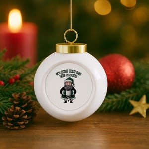 May include: White Christmas bauble with a gold cap and string. The bauble features a cartoon Santa Claus holding a mug, with the text "I'M ONLY HERE FOR THE COOKIES". Festive holiday decoration.