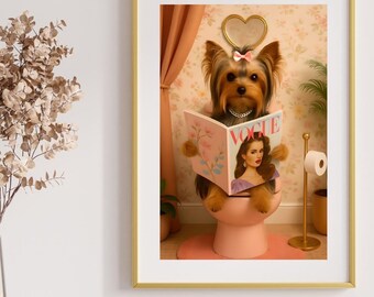 May include: A framed print featuring a Yorkshire Terrier reading a Vogue magazine while seated on a pink toilet. The dog wears a pink bow and a necklace. The background includes a floral wallpaper and a gold-colored frame.