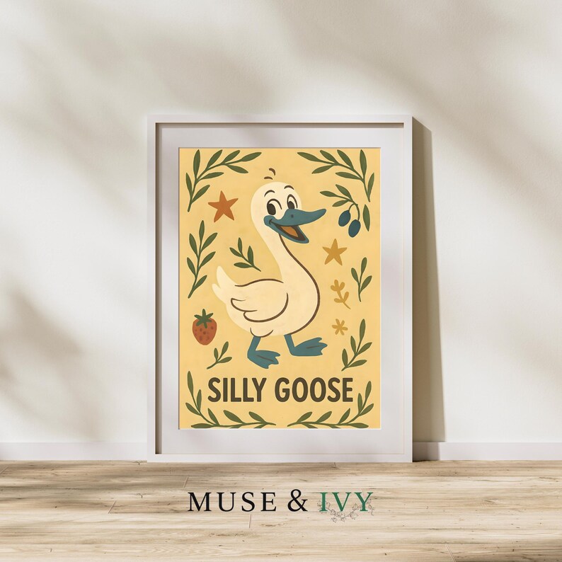 May include: Framed art print featuring a cartoon goose with a smiling face, blue beak, and blue feet. The goose is set against a yellow background with green leaves, stars, and a strawberry. The words "SILLY GOOSE" are below the goose.