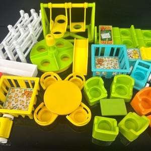 Puede incluir: Una colección de coloridas piezas de plástico para parques infantiles, que incluyen un columpio, un tobogán y varias sillas y mesas. El conjunto presenta componentes amarillos, verdes, azules y naranjas brillantes, con una valla blanca y un carrusel.