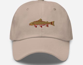 May include: A beige baseball cap with an embroidered brown trout with red markings.