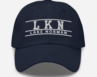 May include: A navy blue baseball cap with white embroidered text that reads "LKN LAKE NORMAN".