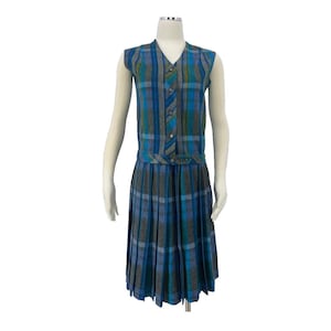 May include: A vintage blue, gray, and teal plaid dress with a sleeveless top and pleated skirt. The top features a V-neck and button details. The dress is displayed on a mannequin against a white background.