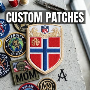 Könnte beinhalten: Eine Sammlung bestickter Aufnäher, darunter ein großer schildförmiger Aufnäher mit einem rot-weiß-blauen Kreuzdesign, einem NFL-Logo und goldenen Löwenakzenten. Weitere runde und quadratische Aufnäher zeigen verschiedene Texte und Grafiken.