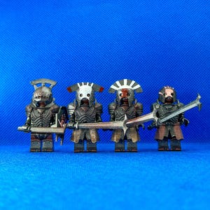 Könnte beinhalten: Vier individuell bemalte Lego-Minifiguren von Orks, die Helme tragen und Schwerter halten. Die Orks tragen schwarze Rüstungen mit roten und weißen Akzenten. Die Schwerter sind silberfarben und haben rote Griffe.