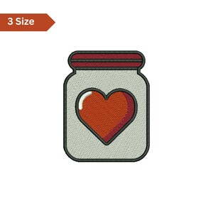 May include: An embroidered design of a jar containing a red heart. The jar has a grey body, a dark red lid, and a black outline. The text "3 Size" is in a brown banner.