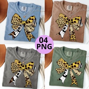 May include: Four short-sleeved crew neck t-shirts in blue, brown, gray, and green, each featuring a large graphic of a decorative bow with a mix of leopard print, cow print, and polka dot patterns. The shirts have a Comfort Colors brand label.