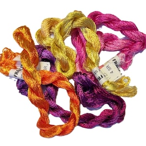 May include: A collection of colorful embroidery floss in shades of orange, yellow, pink, and purple. The floss is twisted into small bundles, with some labeled "FRANCIS". Ideal for various craft projects.