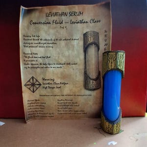 May include: A blue conversion fluid vial with gold accents, labeled "Leviathan Serum." The vial is displayed next to a parchment with text about the serum's properties and warnings. The overall theme is fantasy or science fiction.
