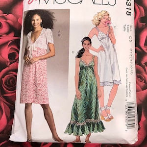 May include: A McCall's sewing pattern envelope featuring illustrations of three different dresses. The envelope is white with the text "Easy McCall's" in red. The pattern number is M5318, and the size is E5 (14-16-18-20-22).