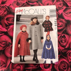 May include: McCall's sewing pattern featuring children's coats and capes. The pattern includes a red cape with a matching hat, a black and white checkered coat, a plaid coat, and a blue hooded cape. The pattern number is 7359.