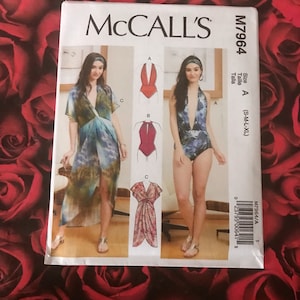 May include: McCall's sewing pattern M7964 for sizes S-M-L-XL. The pattern includes three different styles: a long, flowing dress with a wrap design, a halter-style swimsuit, and a shorter dress with a knotted front.