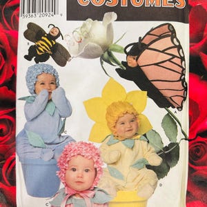 May include: A Simplicity Costumes sewing pattern envelope, number 7868, size A 1/2, 1, 2, 3, 4. The front displays illustrations of infants wearing costumes resembling a bee, a butterfly, a blue flower, and a yellow flower, with text labels.