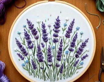 May include: A handcrafted embroidery hoop featuring a lavender field design. The artwork showcases purple lavender flowers, white and blue accents, and green stems on a white fabric. The wooden hoop is visible, along with spools of thread and scissors.