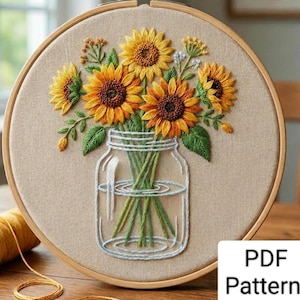 May include: Embroidered sunflower bouquet in a mason jar, displayed in a wooden embroidery hoop. The sunflowers are yellow and orange, with green leaves. The jar is outlined in white thread. The text "PDF Pattern" is in the bottom right corner.