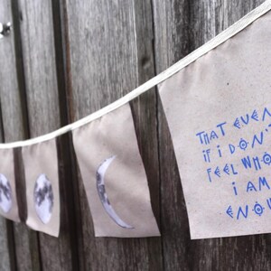 K&ouml;nnte beinhalten: Ein Banner mit wei&szlig;em Hintergrund und blauem Text, der "That even if I don't feel whole I am enough." lautet. Das Banner h&auml;ngt an einem Holzzaun.