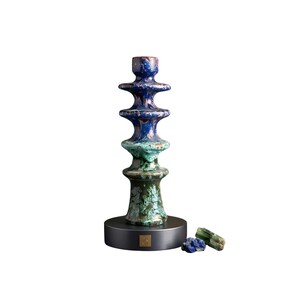 Può includere: Un portacandele in ceramica a strati, nei toni del blu e del verde. La base è grigio scuro e il portacandele è accompagnato da piccoli campioni di minerali blu e verdi. Un elemento decorativo per la casa.