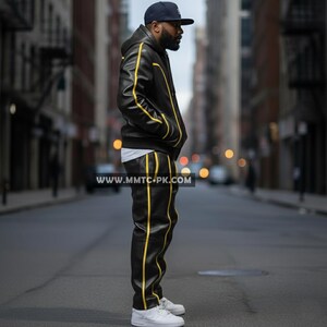 May include: Black leather jacket and pants set with yellow stripes. The jacket has a hood and the pants have a straight leg design. The outfit is worn with a navy blue cap and white sneakers. The website address "www.mmtc-pk.com" is visible.